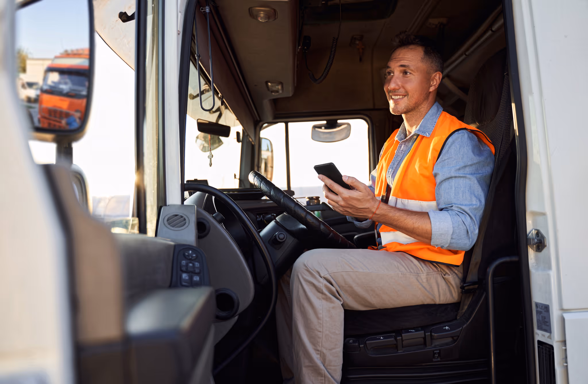 Two engineers in industrial or warehouse facility looking down at a tablet.