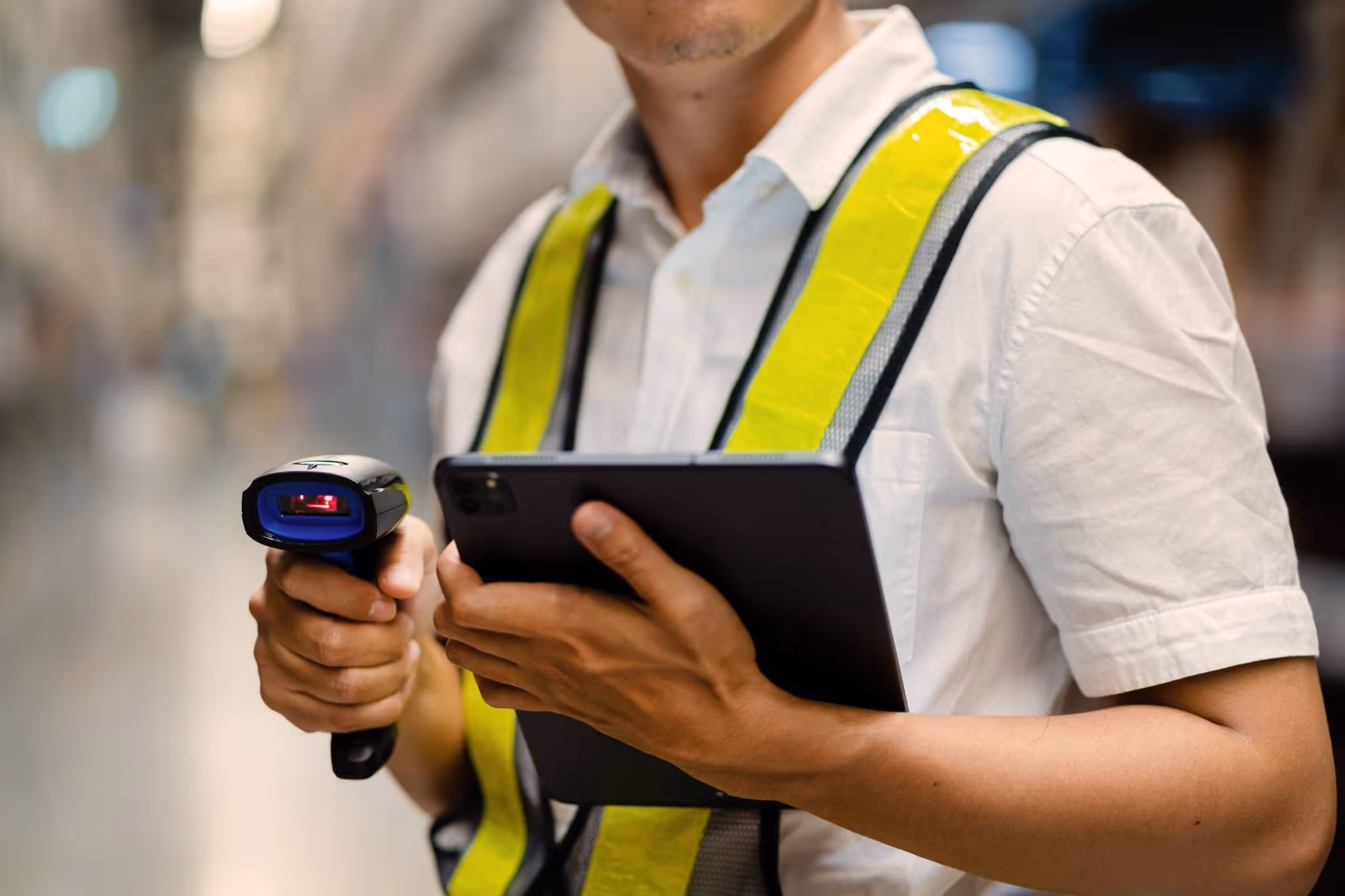 Warehouse employee with tablet using barcode scanner