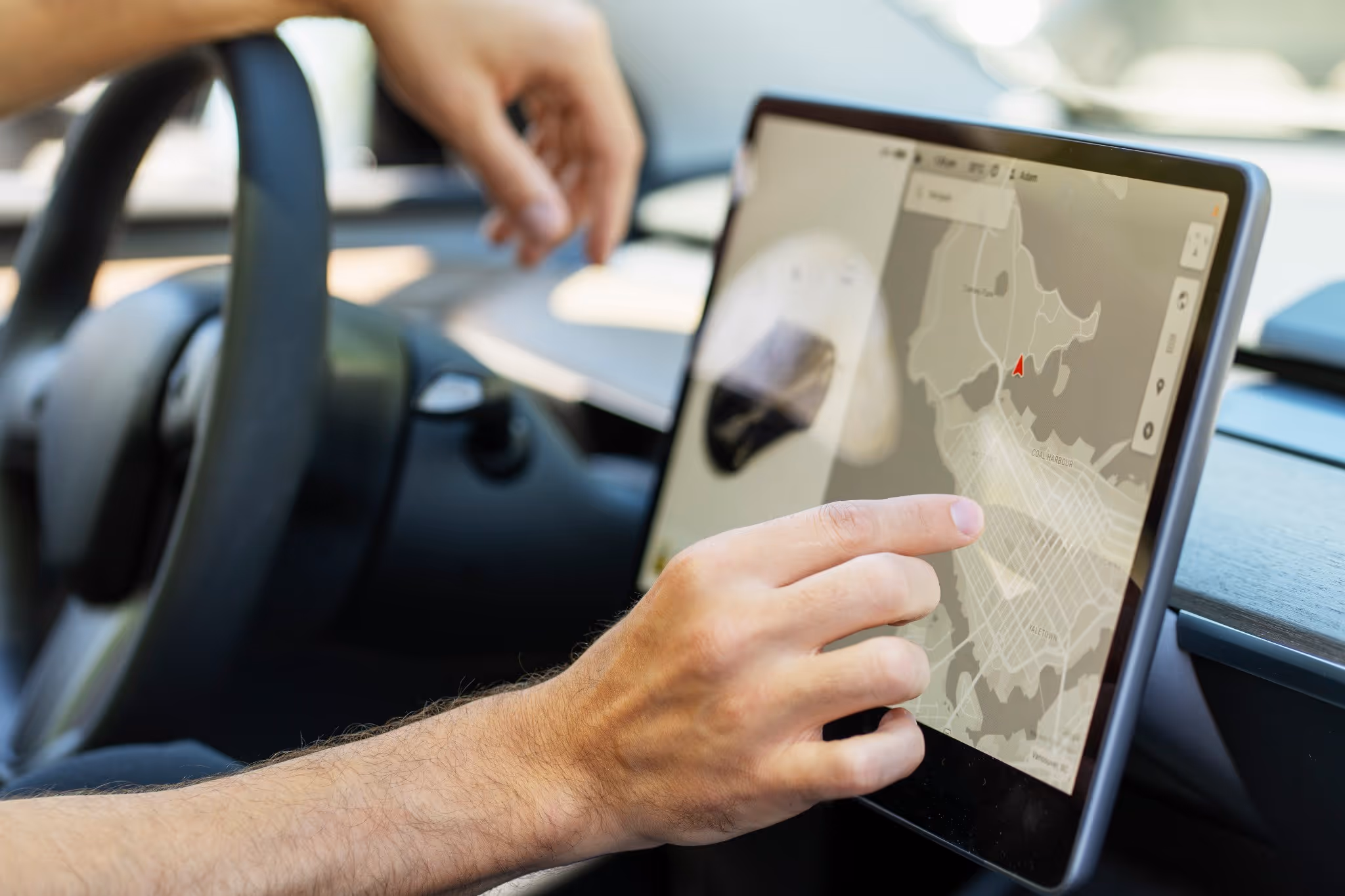 person in a car using tablet screen with map on it
