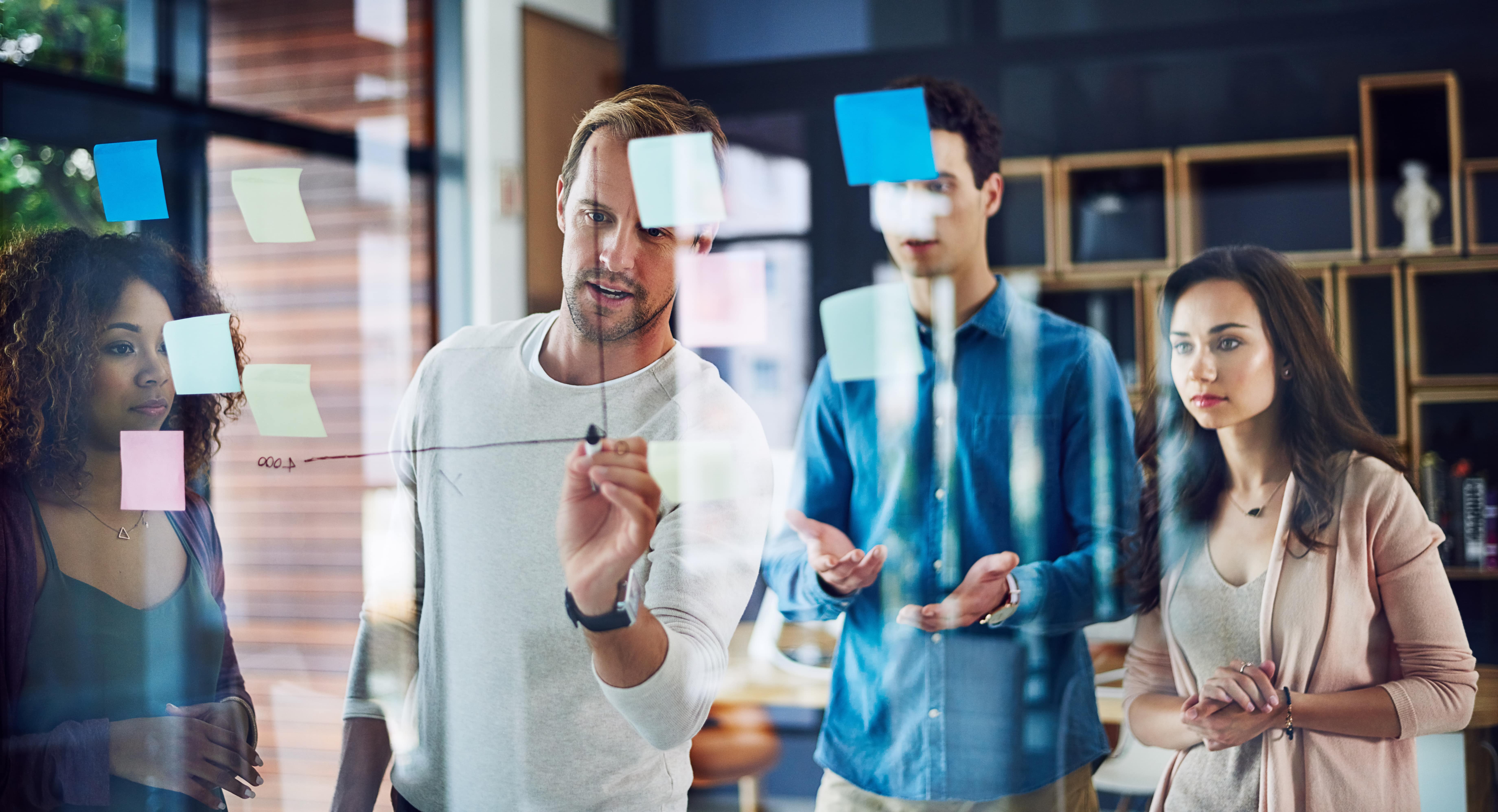 Lean Sherpas Team entwickelt gemeinsam eine Strategie an der Glaswand