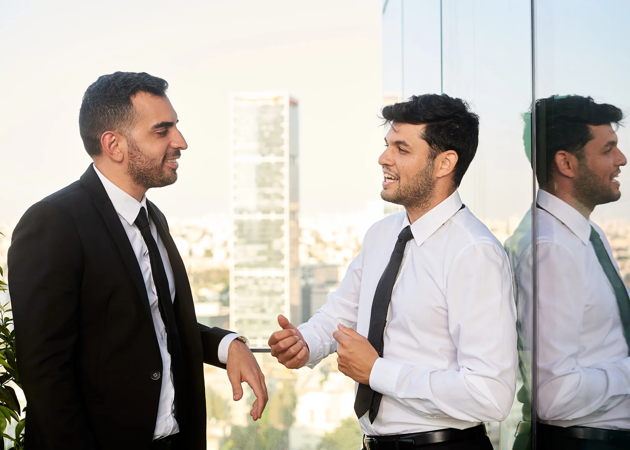 צילומי תדמית במשרד של שני אנשי מקצוע בשיחה ליד חלון