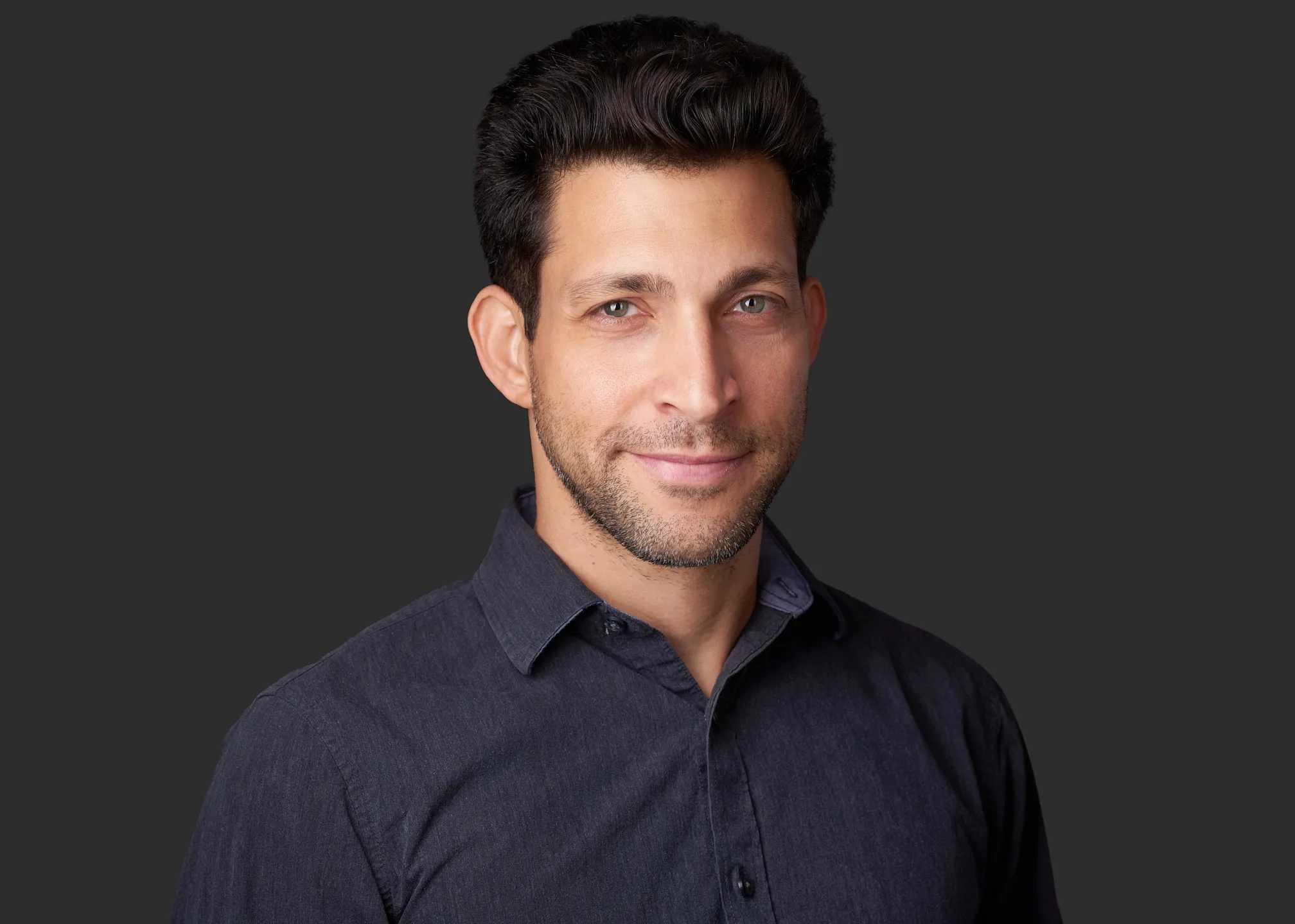תמונת תדמית מקצועית של גבר בחולצה כהה על רקע שחור