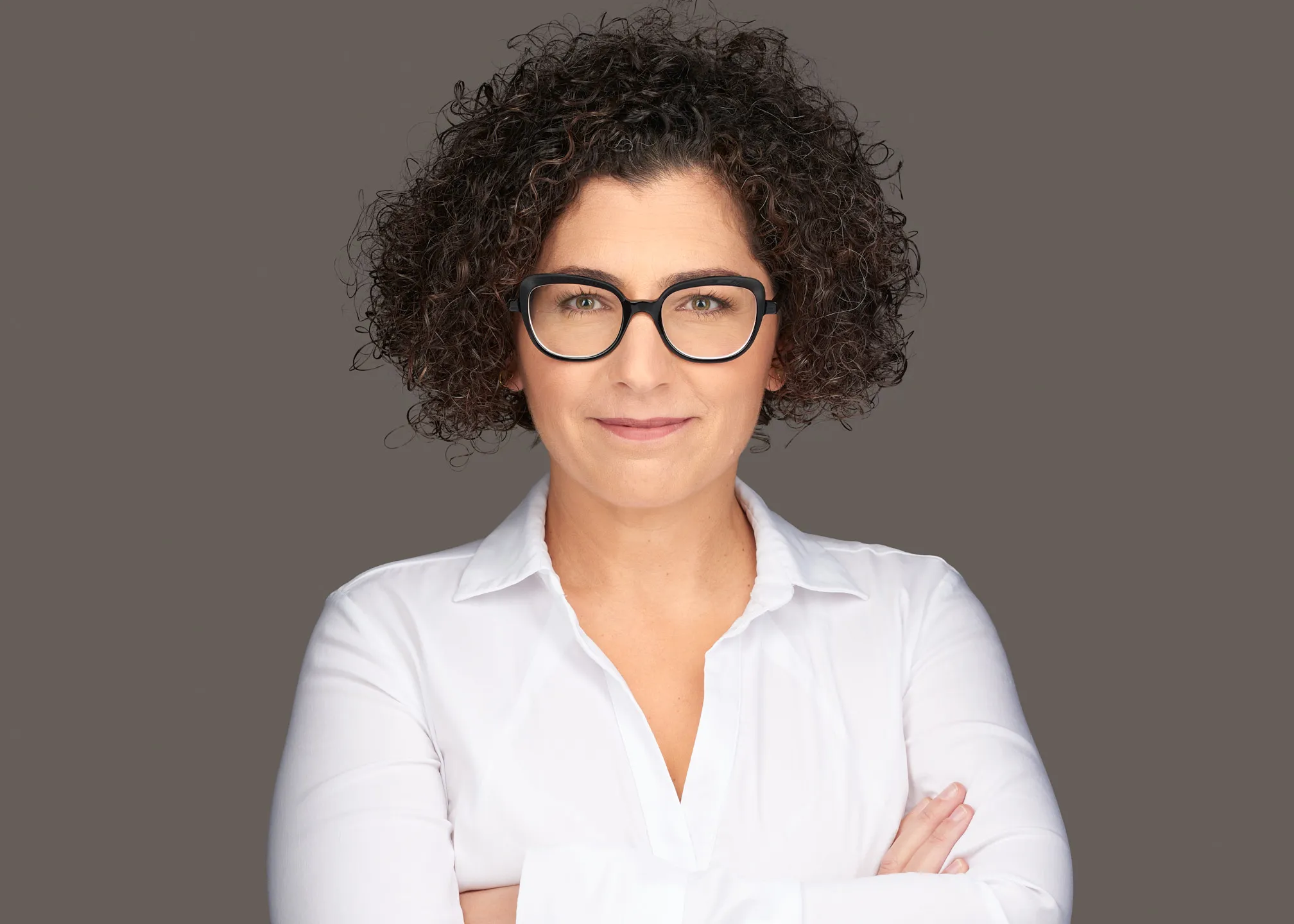 צילום תדמית בסטודיו של אישה עם משקפיים וחולצה לבנה
