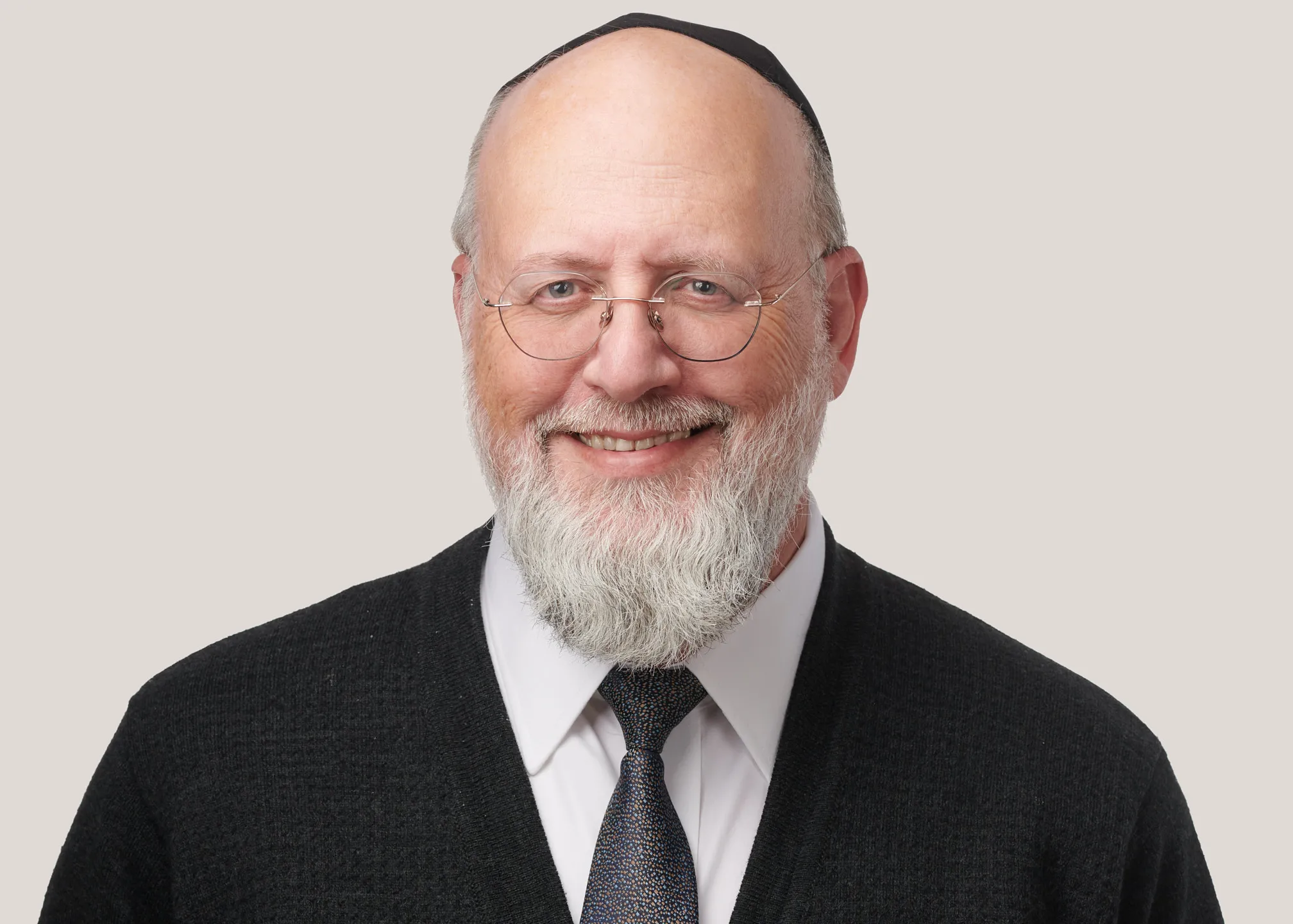תמונת פרופיל מקצועית של גבר עם זקן ומשקפיים על רקע בהיר