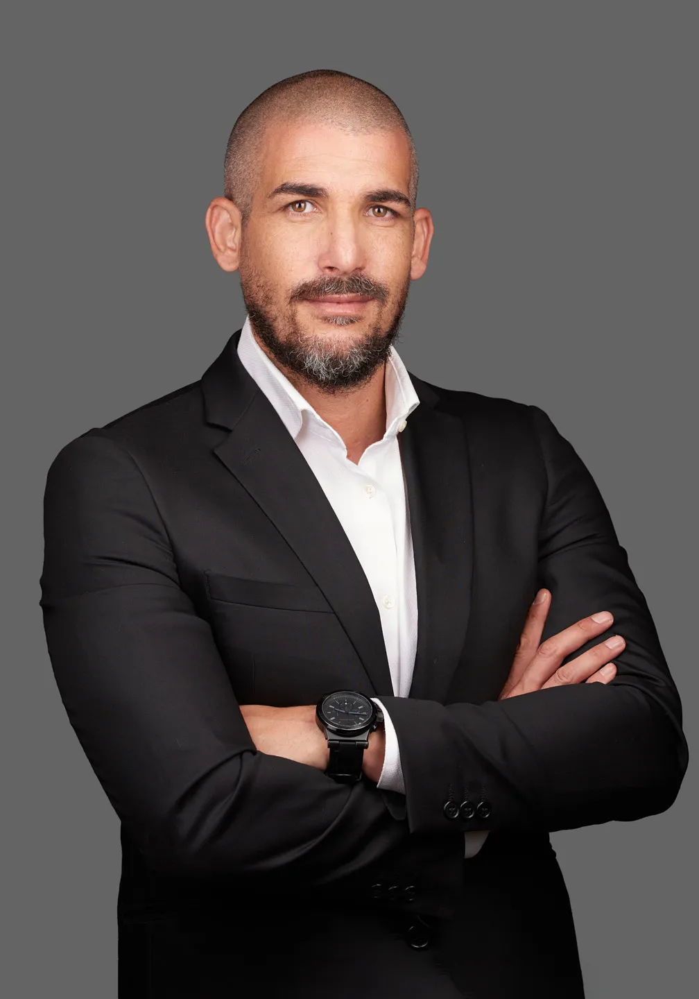 תמונת תדמית לעורך דין בחליפה שחורה על רקע אפור לצילומי תדמית לעורכי דין