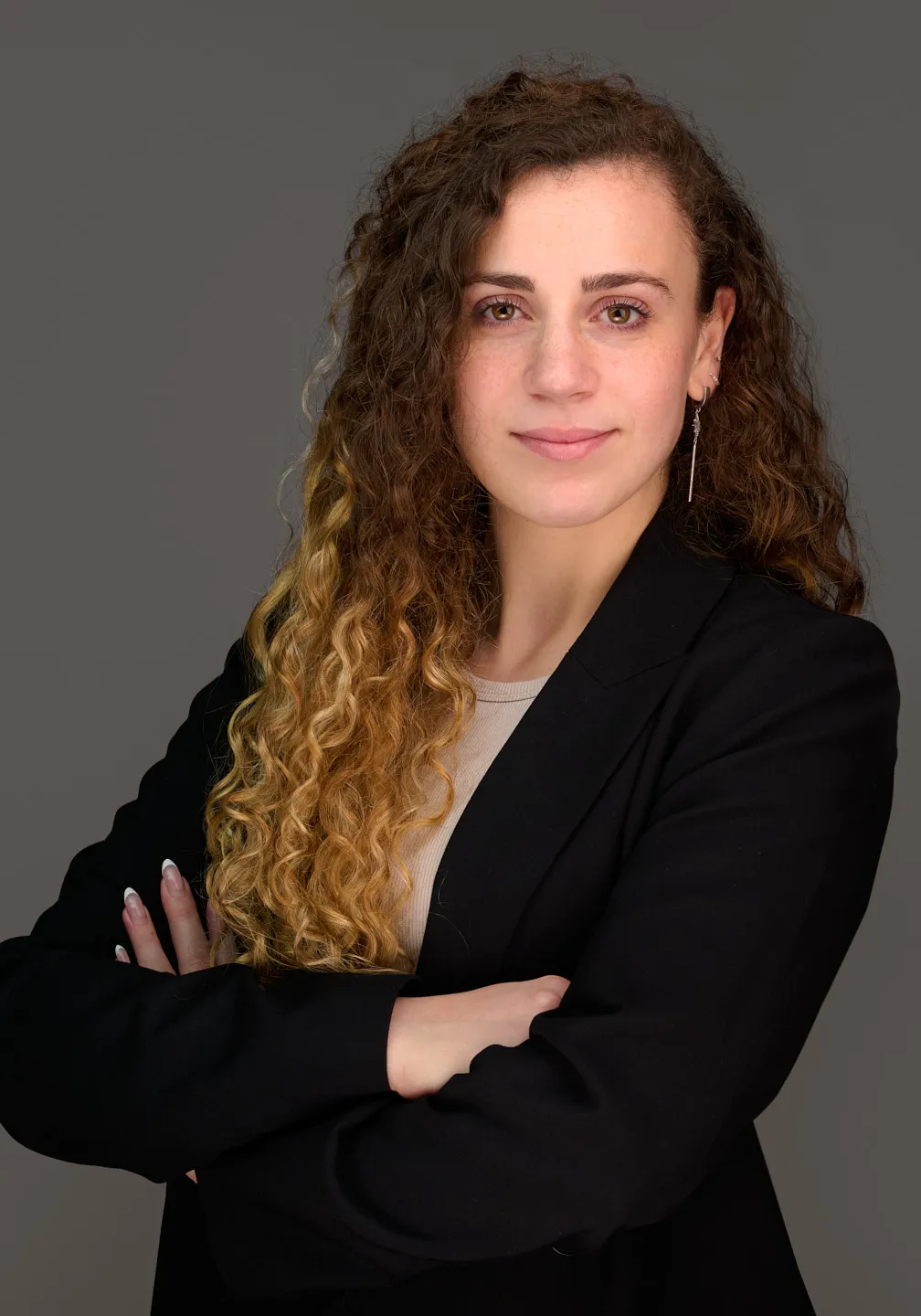 צילום תדמית לעורכת דין בבלייזר שחור על רקע אפור לתמונת פרופיל מקצועית