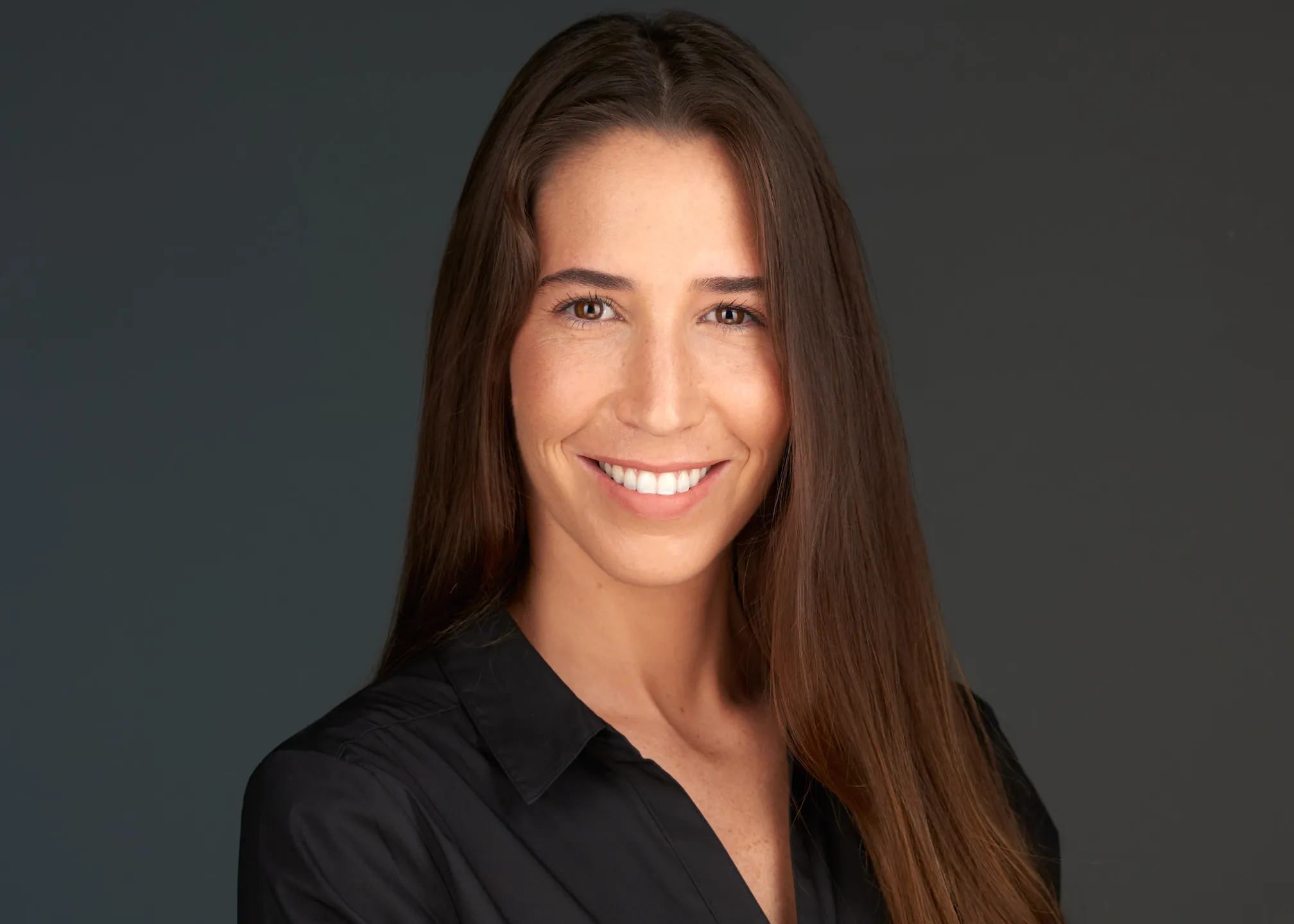 תמונת פרופיל ללינקדאין של אישה בחולצה שחורה על רקע כהה