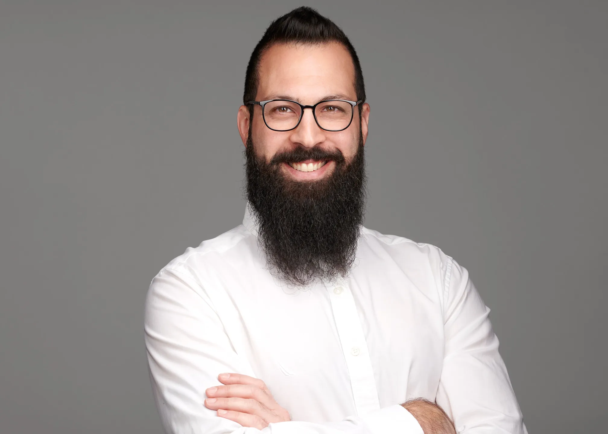 תמונת פרופיל מקצועית של גבר עם זקן ומשקפיים על רקע בהיר