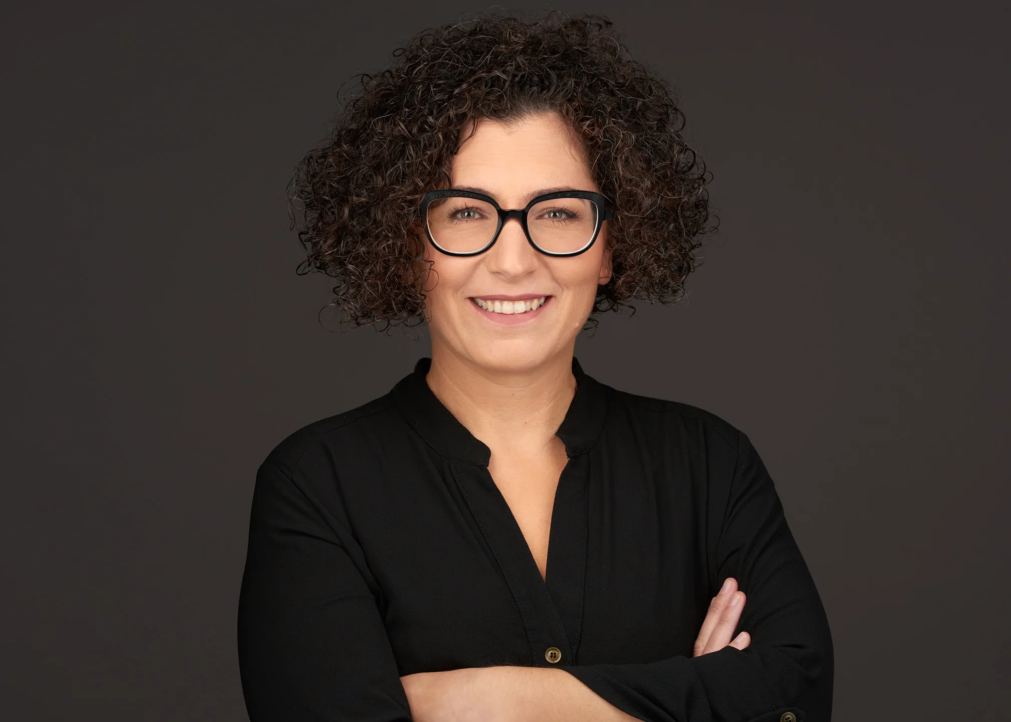 צילום פרופיל מקצועי של אישה עם משקפיים וחולצה שחורה