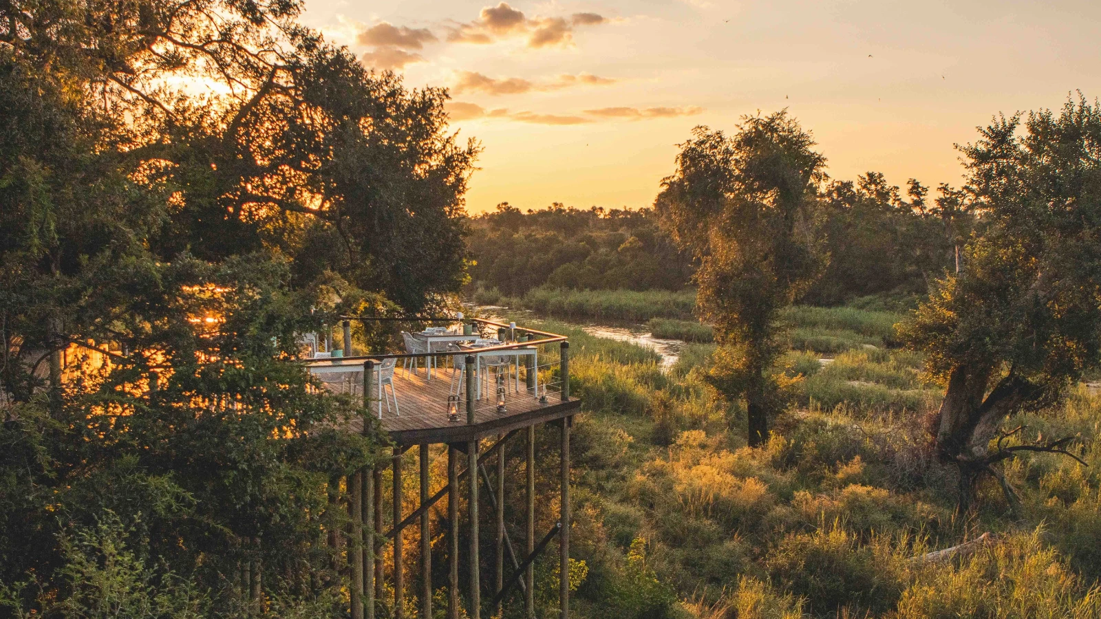 Wild Together: My Wife’s First Safari at Monwana: raised wooden deck dining area overlooking a river at sunset