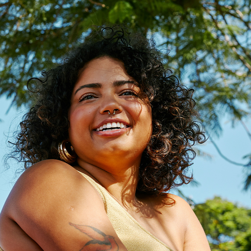 Smiling woman with curly hair. Clean Slate Clinic client.