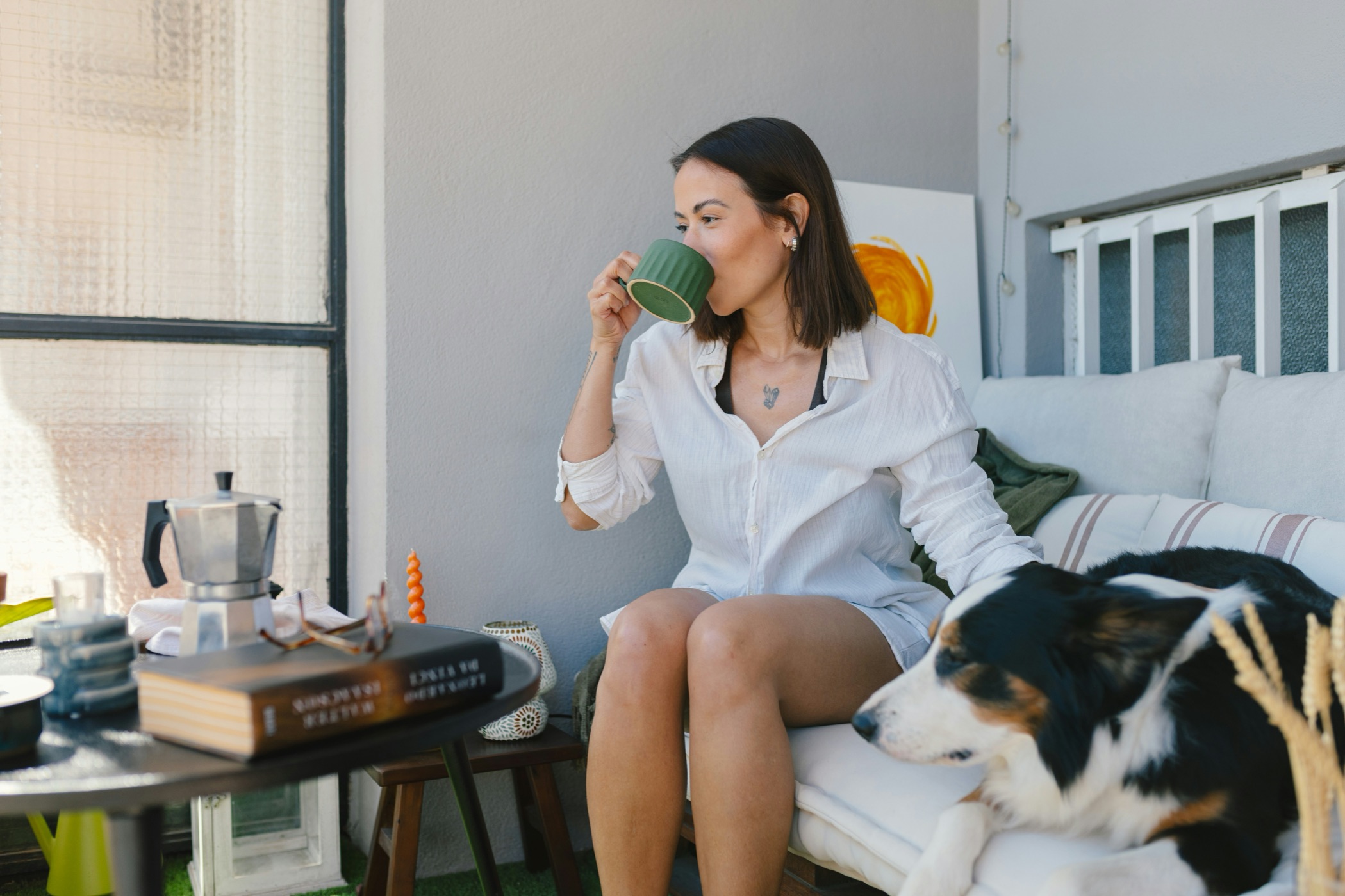 A woman relaxing at home with a coffee and her dog