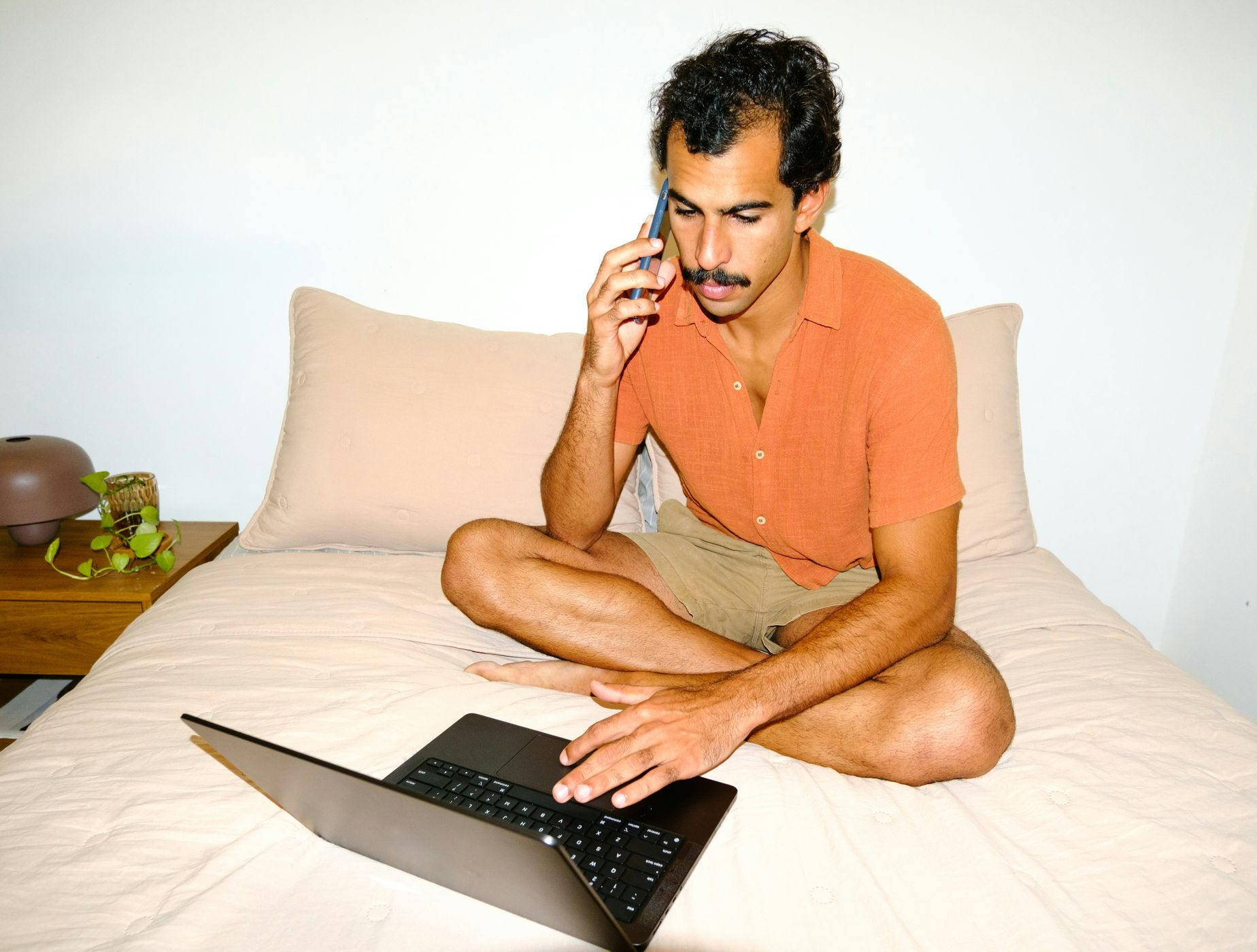 A man at home on a phone call with his laptop