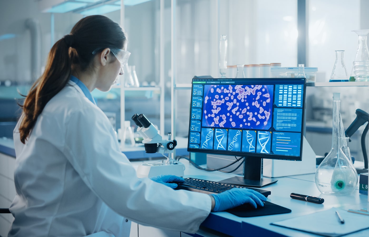 Scientist analyzing DNA and cell images for gene therapy research.