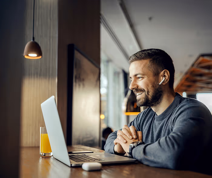 Smiling young male working with laptop