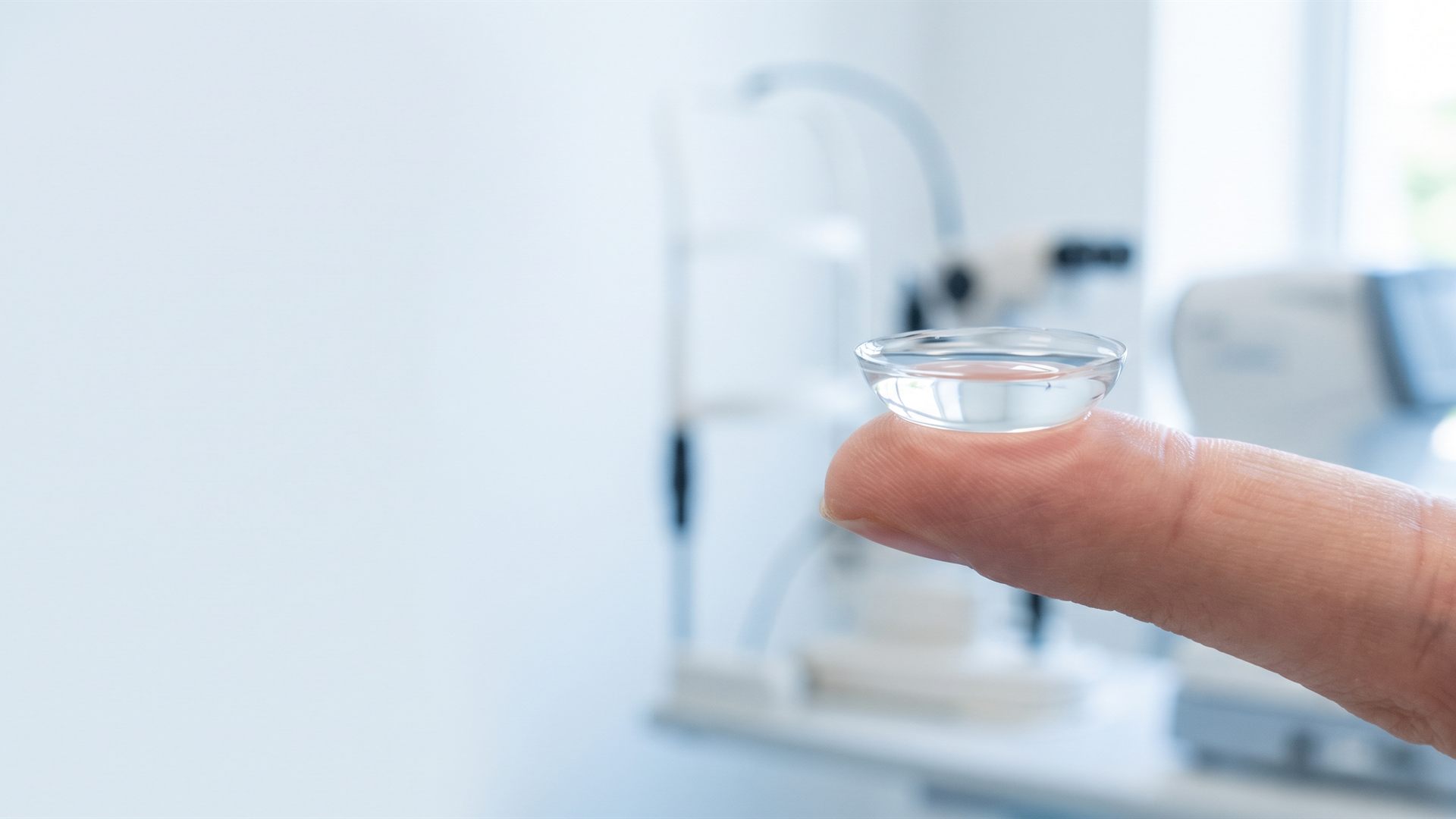Close-up of an eye wearing a clear scleral contact lens, its edge resting on the white of the eye.
