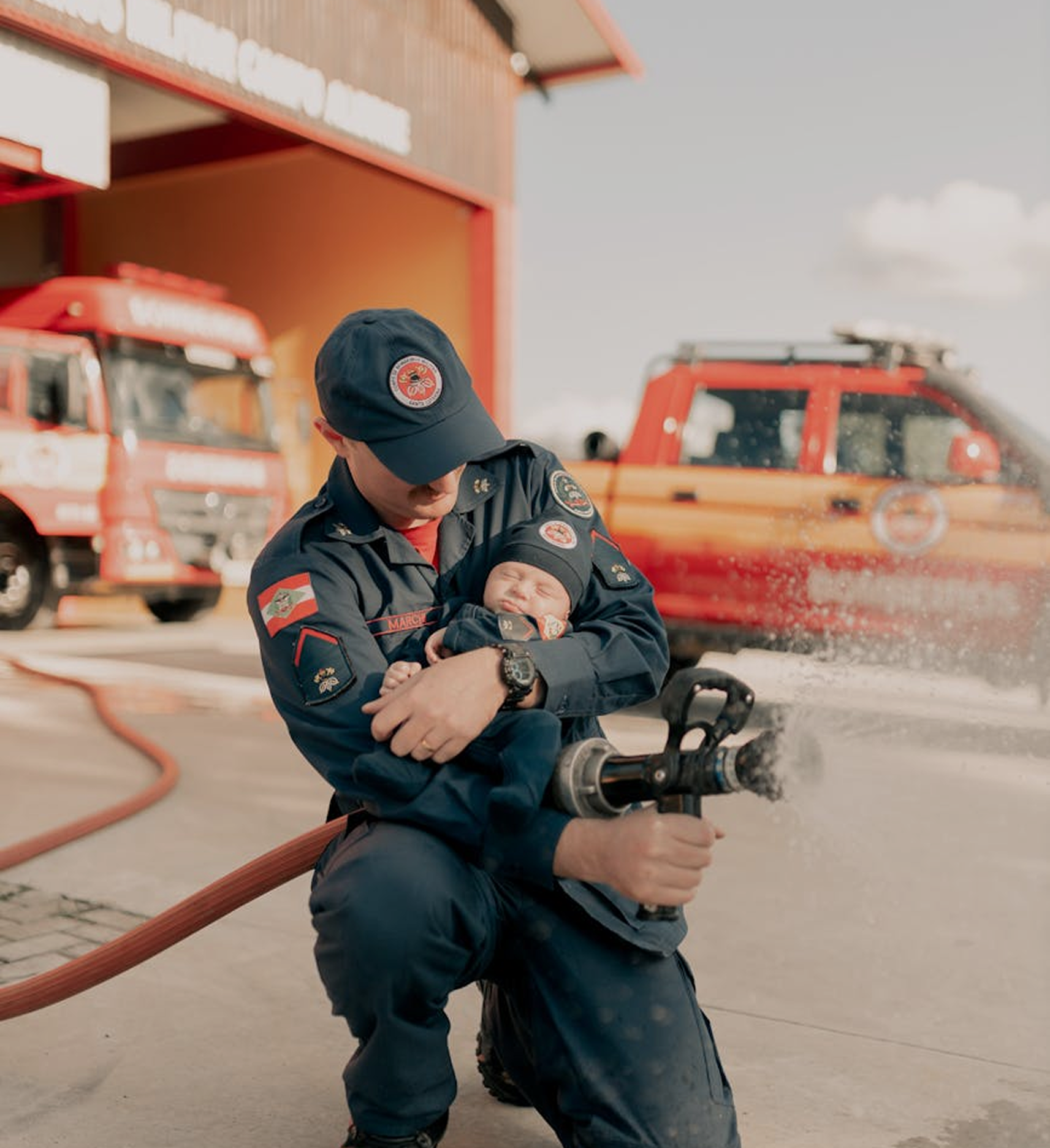 Fire fighter bringing a baby white do splashing water