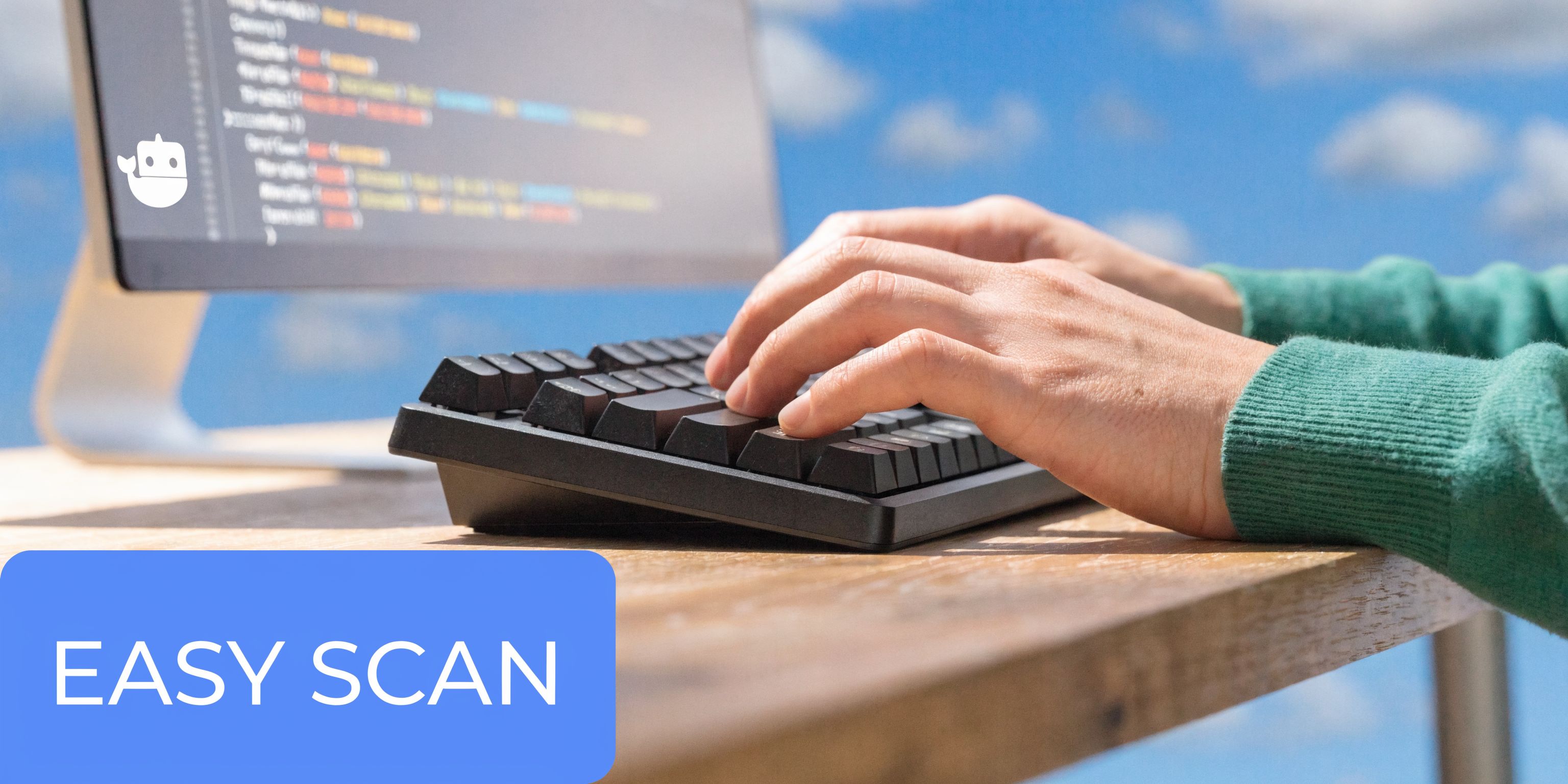 A person typing on a mechanical keyboard with a computer screen showing code in the background.