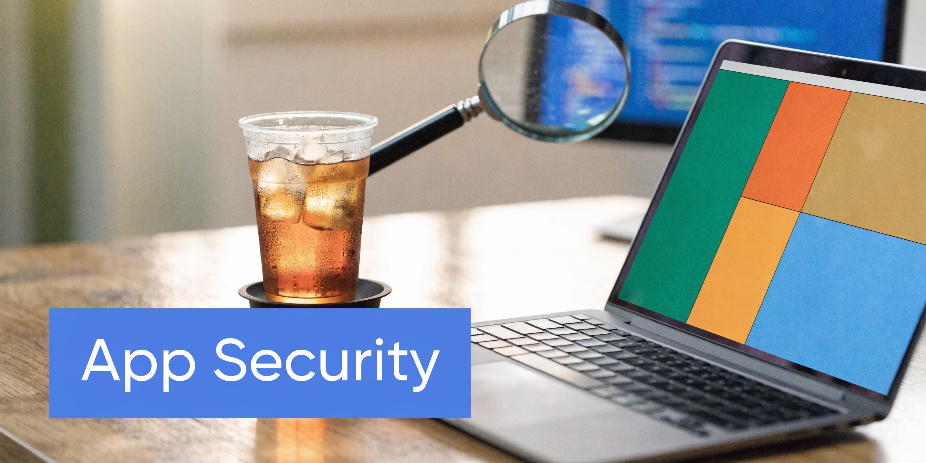 A modern workspace with a laptop displaying a colorful interface, a magnifying glass, and iced tea.