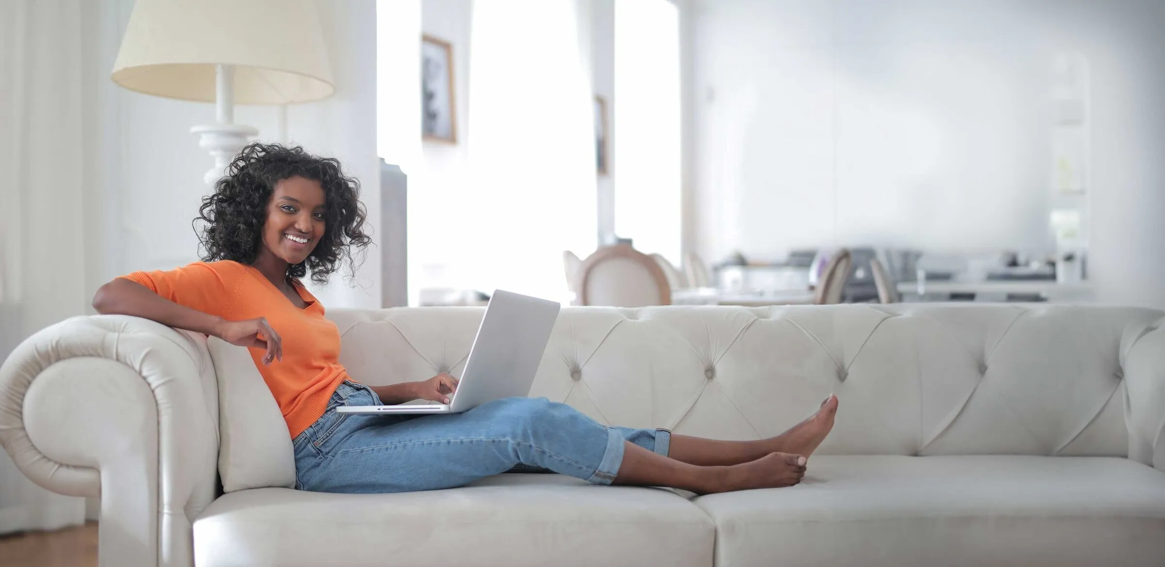 Woman on sofa working on a laptop