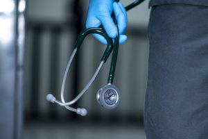 Allied healthcare worker holding stethoscope after working with a medical staffing agency to find travel assignments