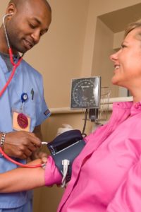 nurse taking blood pressure during a travel assignment after finding the right travel nurse agency for him
