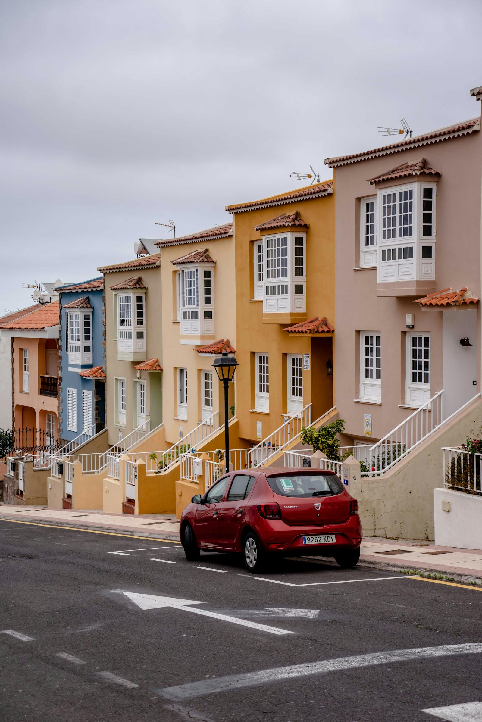 Compact rental car parked on Spanish coastal street - affordable car rental Spain
