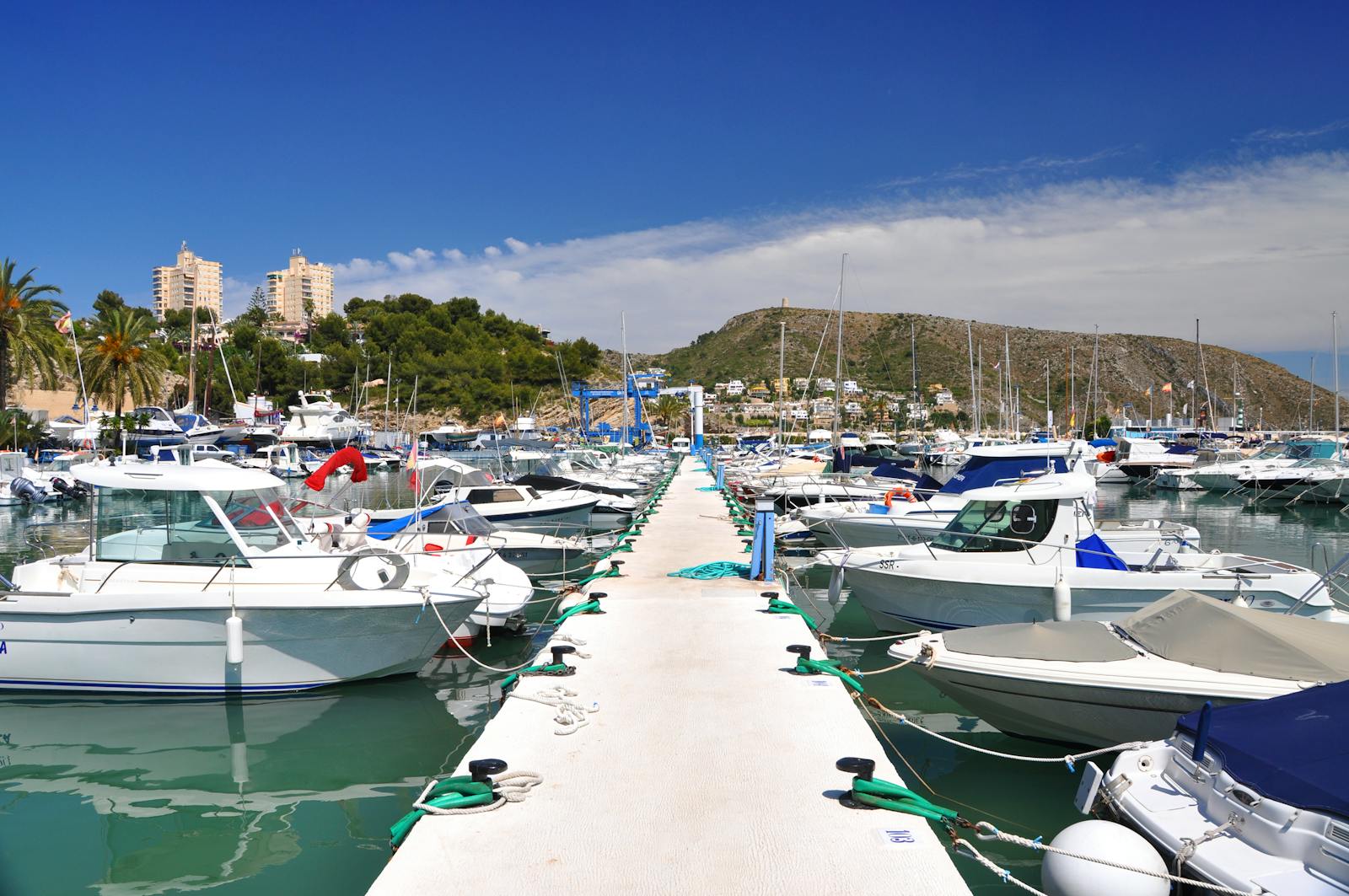 Moraira marina with boats and coastal hill - rent a car Moraira