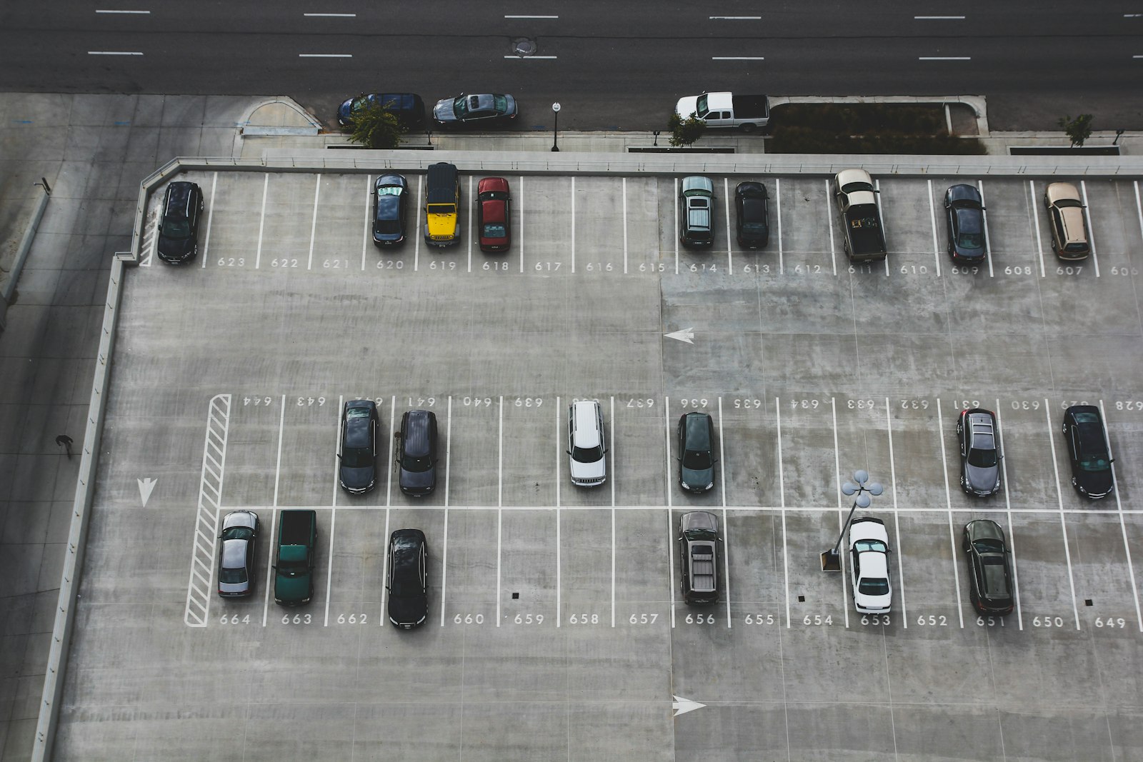 Parking lot with rows of ordinary cars seen from above