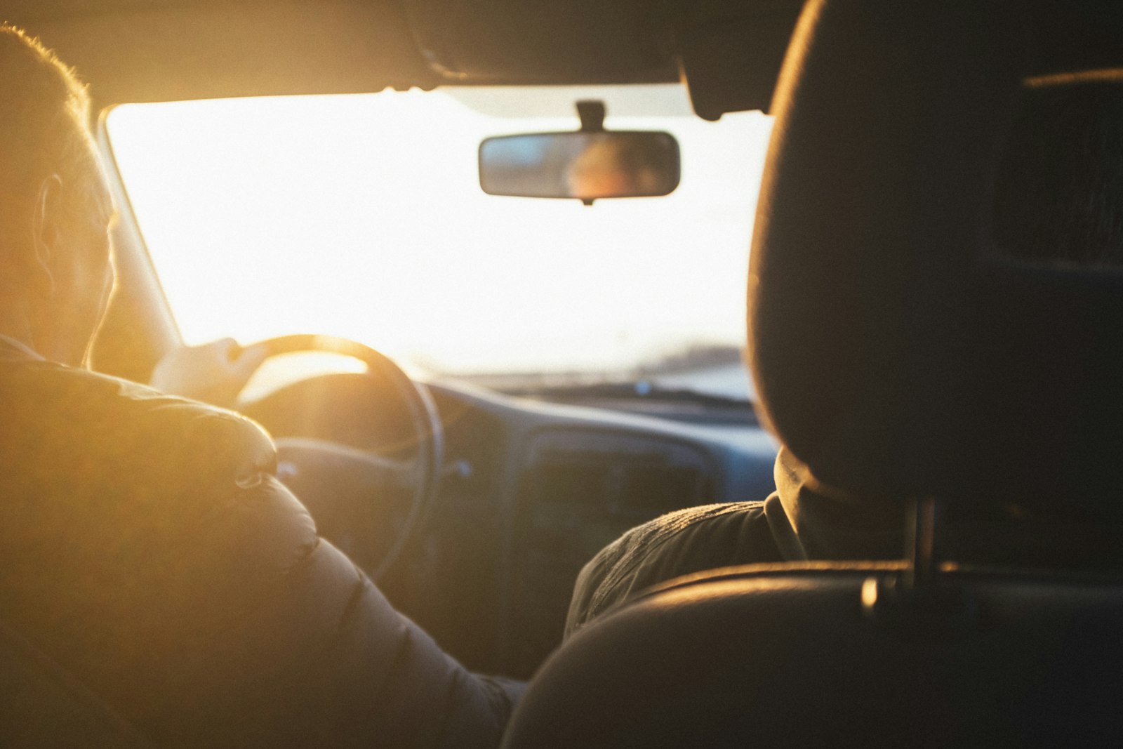 Driver at the wheel of a rental car in warm golden light on the road to Alicante