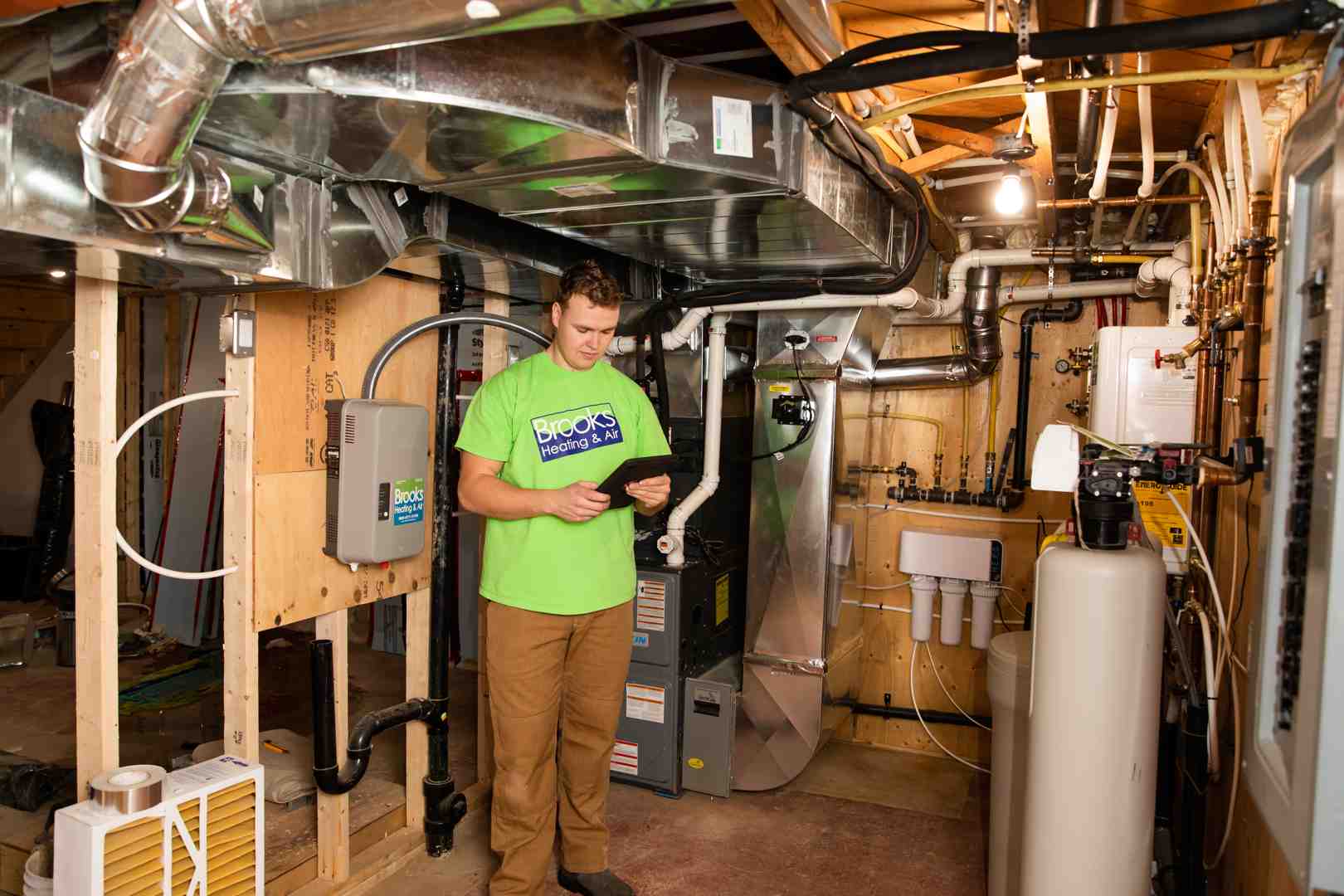 A technician performing a home assessment for HVAC sizing - HVAC Heat Pump and Furnace Installation Cost In Milton, Ontario Canada