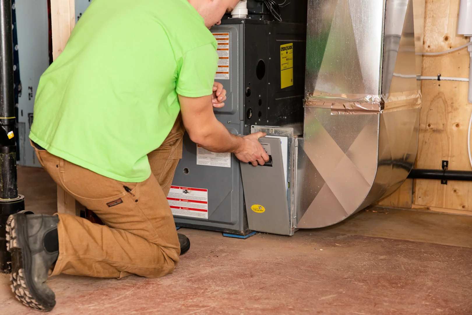 HVAC technician inspecting residential furnace during preventative maintenance visit - is an hvac maintenance plan worth it HVAC technician inspecting residential furnace during preventative maintenance visit - is an hvac maintenance plan worth it