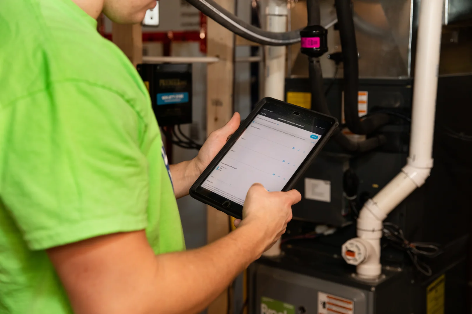 HVAC technician inspecting a modern residential heating and cooling system - what does an hvac maintenance plan include HVAC technician inspecting a modern residential heating and cooling system - what does an hvac maintenance plan include