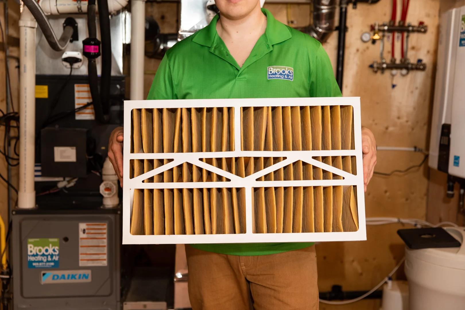 Technician comparing a dirty, dust-caked evaporator coil to a professionally cleaned, shiny silver coil - ac tune up guide