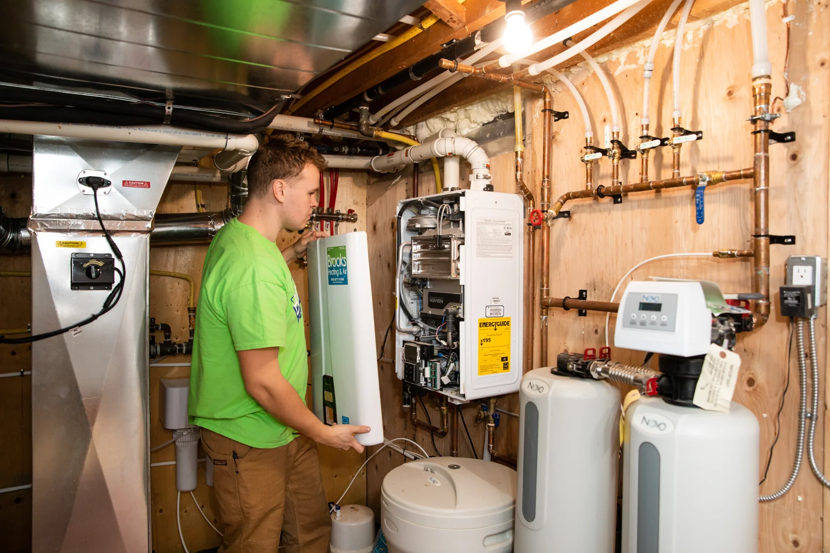 A lineup of different modern water heater systems in a residential basement