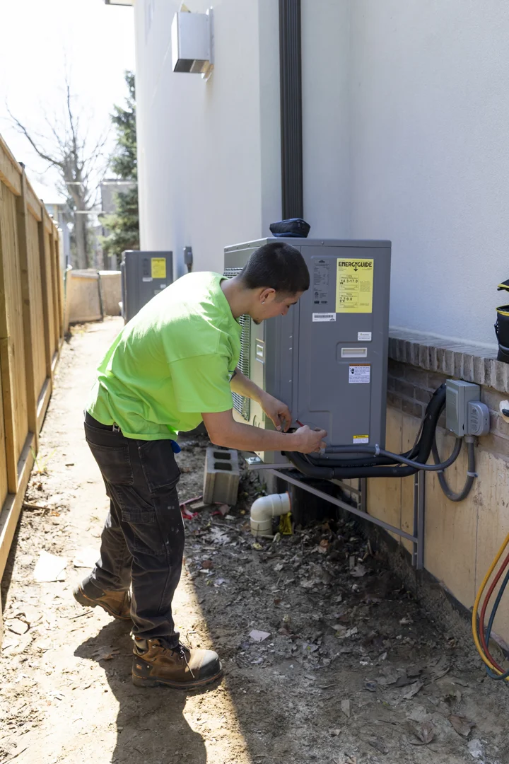 HVAC technician inspecting an outdoor condenser unit in Georgetown Ontario HVAC technician inspecting an outdoor condenser unit in Georgetown Ontario