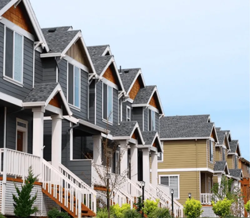 Row of modern townhouses with gray siding and white railings