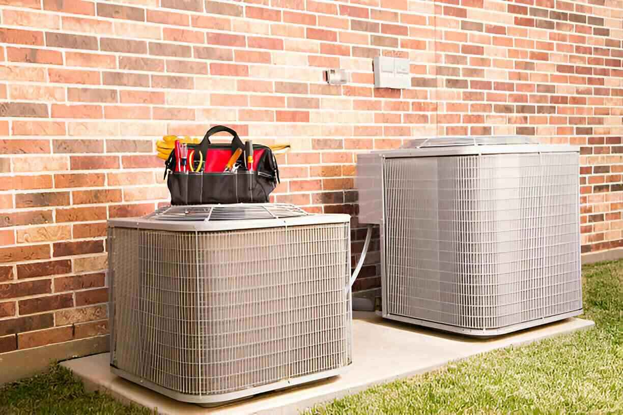 HVAC units with toolbag on brick wall background, ready for maintenance