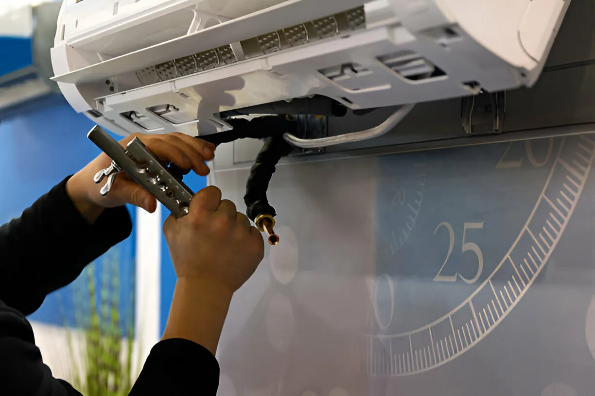 Technician repairing air conditioning unit with tool near measuring scale