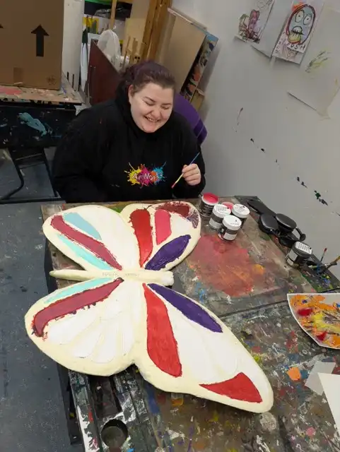 Fran Cooper smiling while working on Butterfly artwork for Wentworth Woodhouse