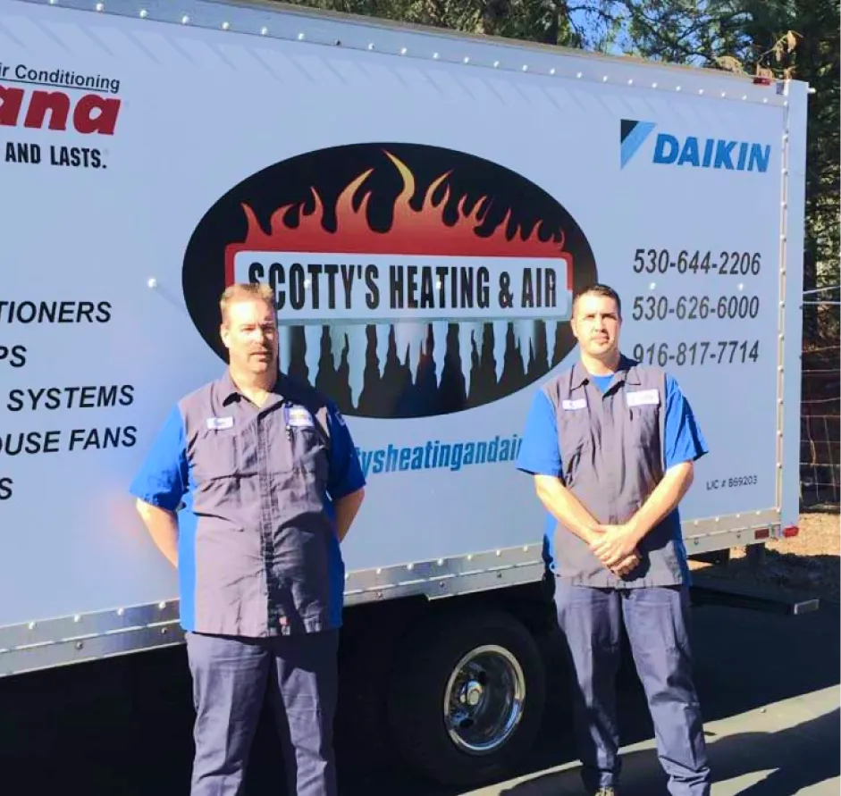 Two technicians standing in front of Scotty's Heating & Air service truck