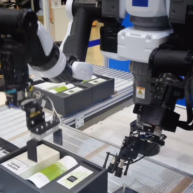 Industrieroboter mit Greifarm, die Verpackungen in einer automatisierten Produktionslinie handhaben.