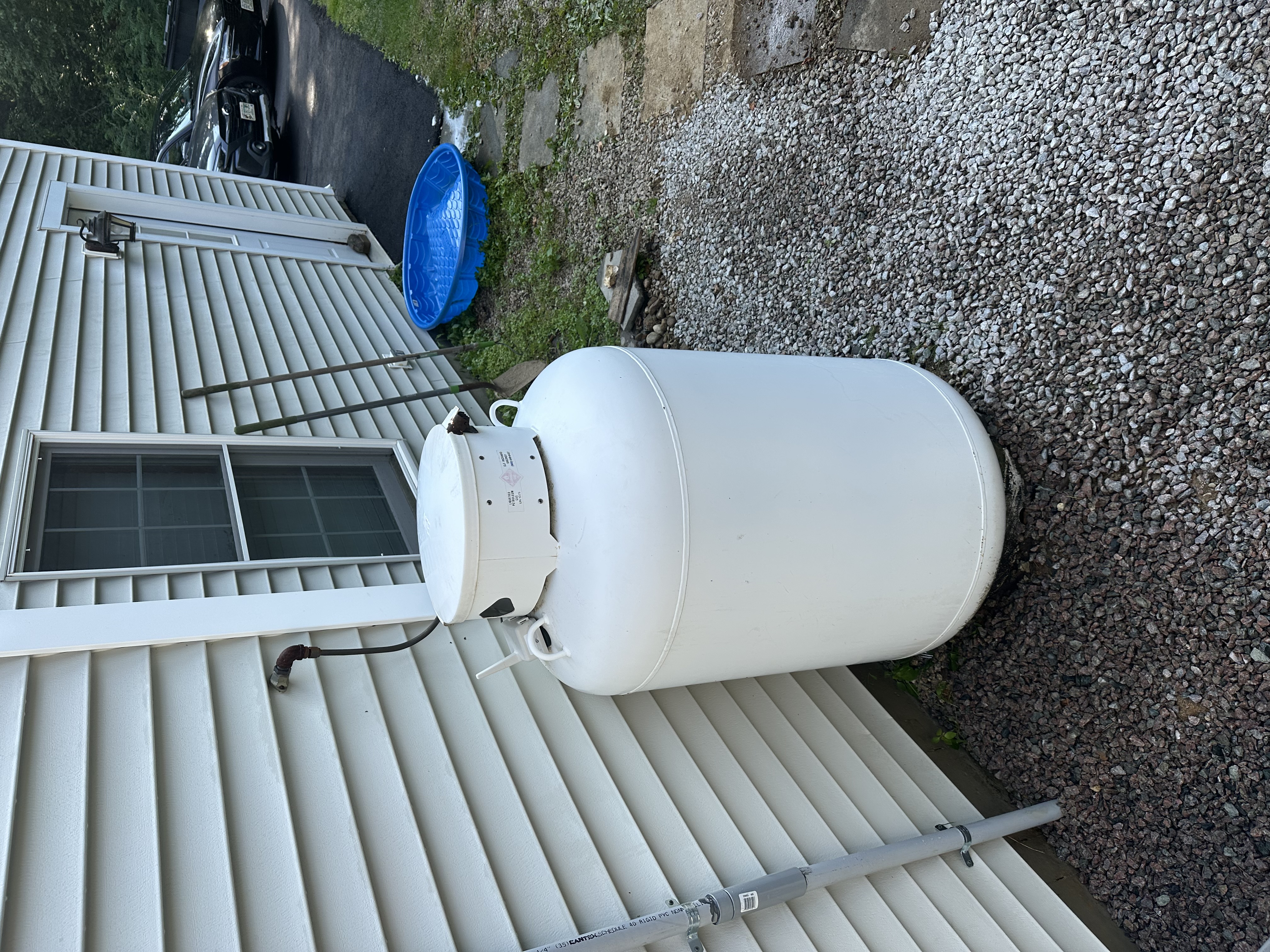 Propane tank and siding before pressure washing