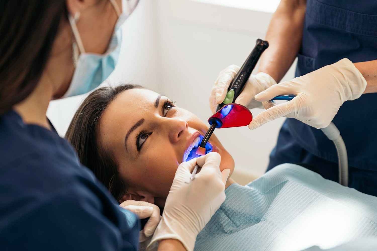 Dentist performing laser gum contouring in dental clinic