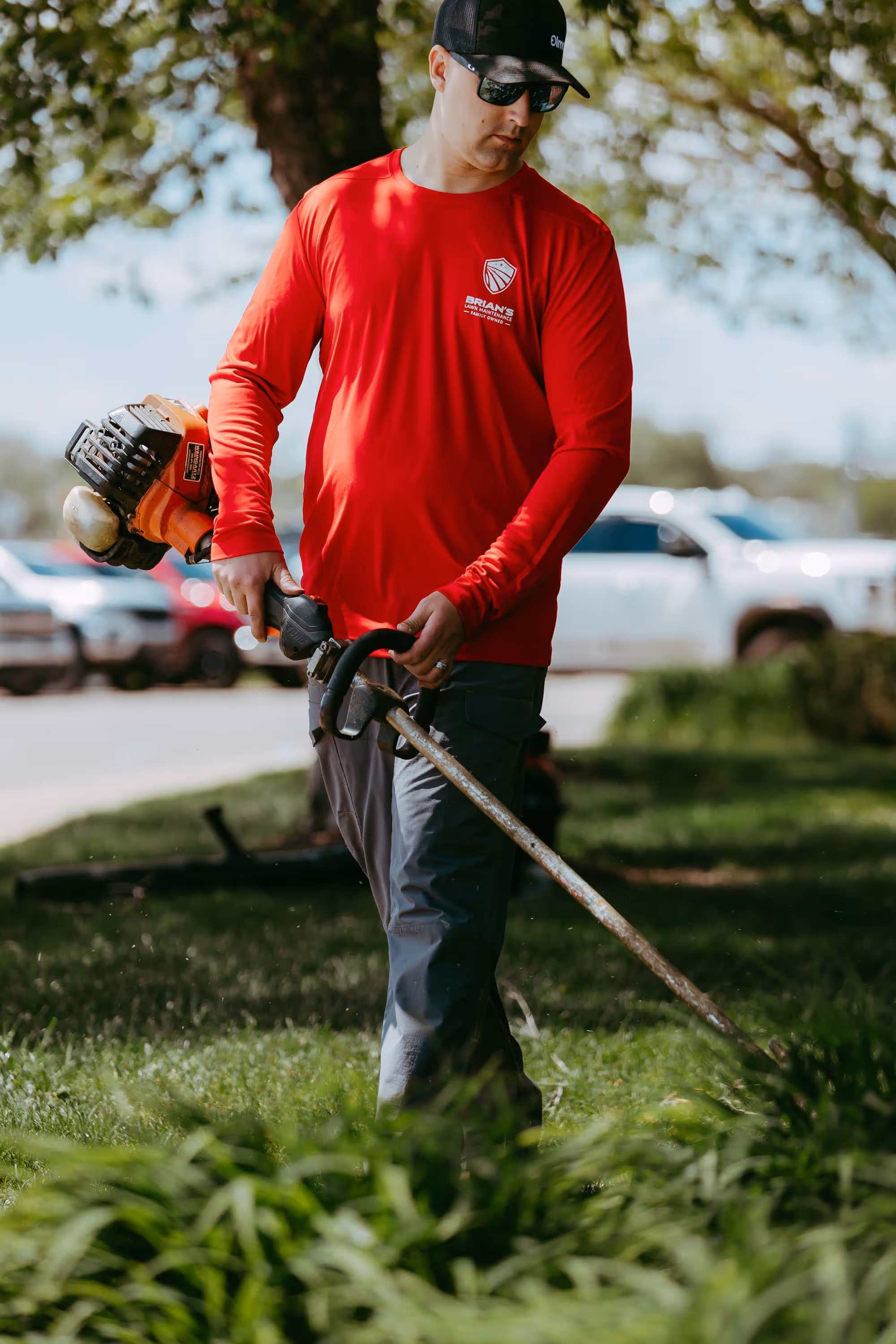 Uniformed team trimming shrubs at New Hudson industrial property