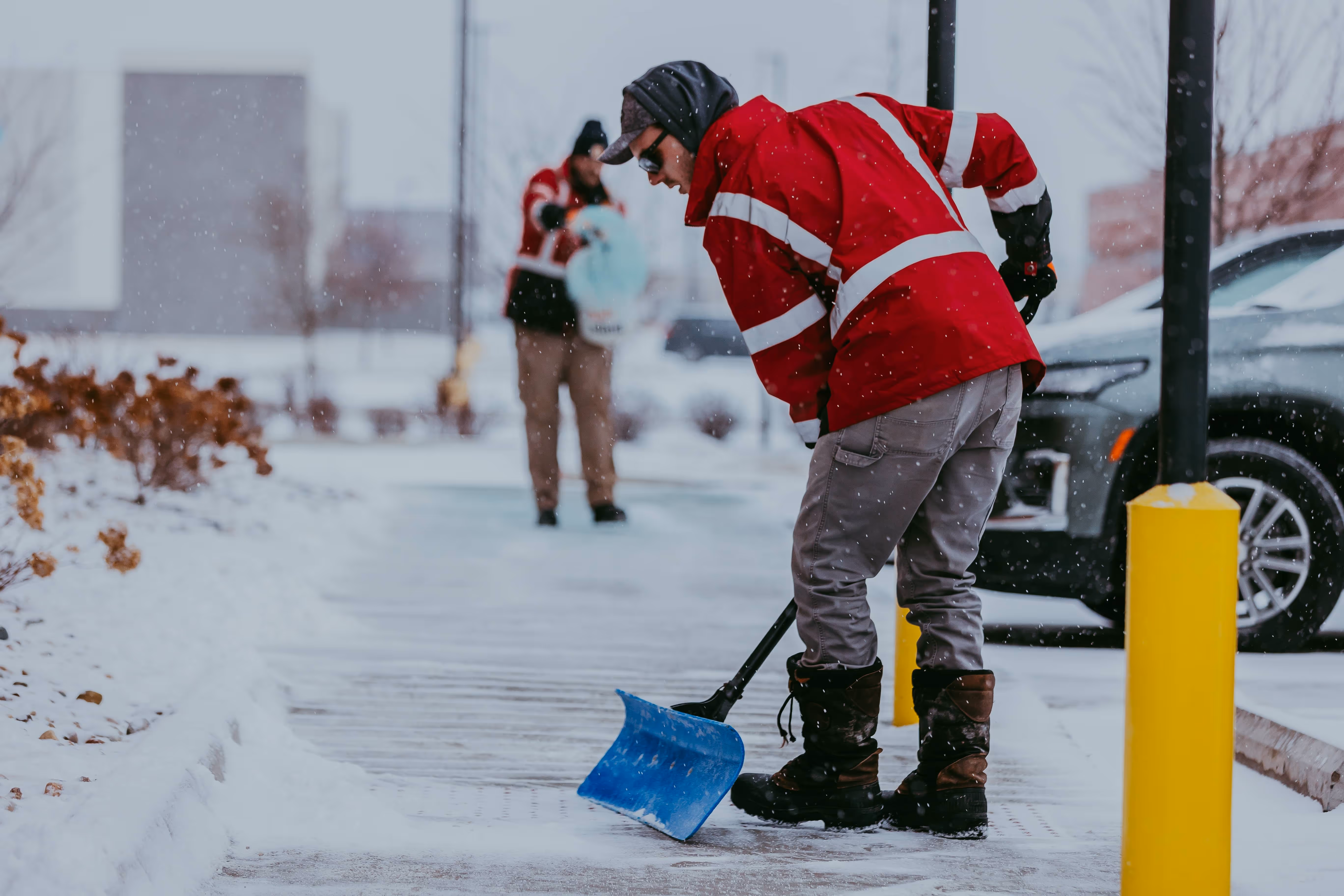 Snow plowing clearing parking lot lanes at Wixom office park