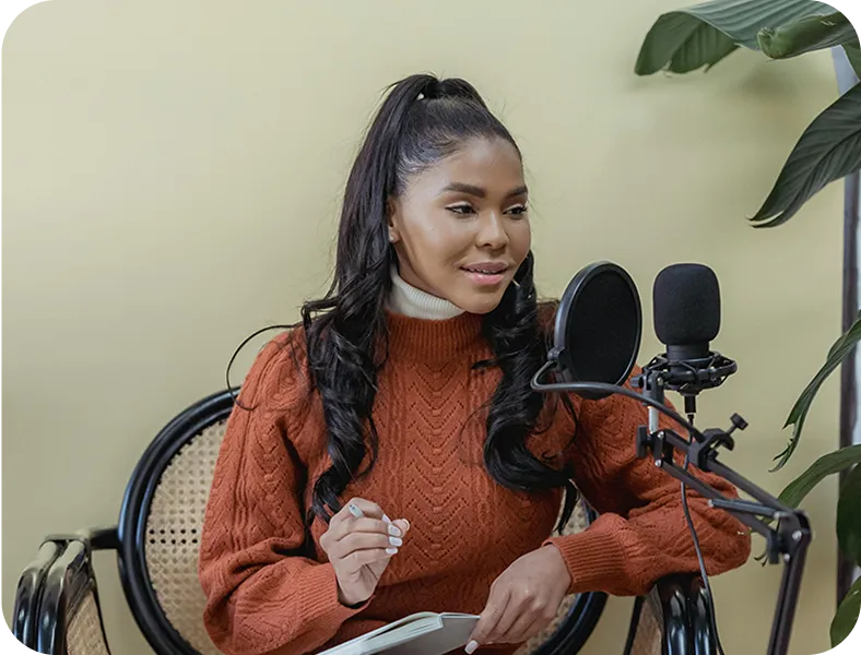 A woman sitting in a chair in front of a microphone.