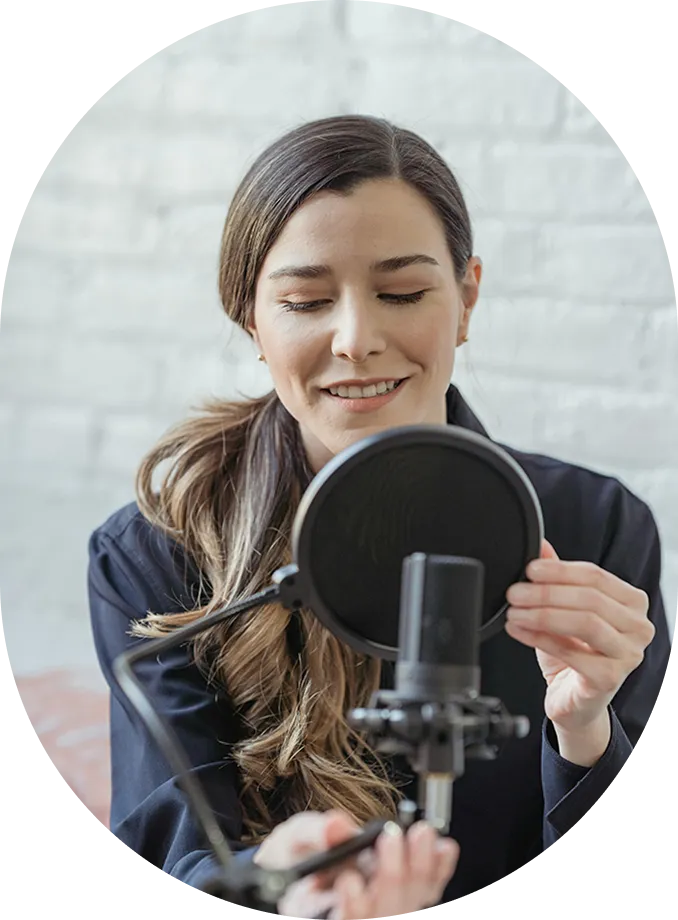 A woman holding a microphone in front of a mirror.