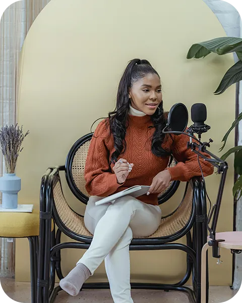 A woman sitting in a chair with a microphone.