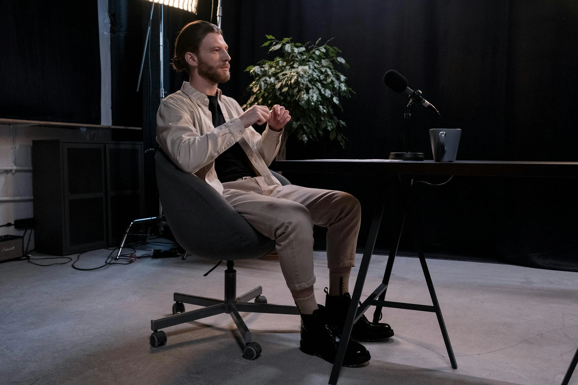 A man sitting at a desk in front of a microphone.